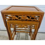 2 Oriental nesting tables with shaped legs and carved pierced work detail of grape vine design.