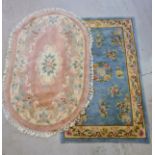 2 vintage Chinese design rugs. A rectangular pale blue ground rug and an oval shaped pink ground rug