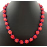 A 17" alternating sea bamboo/coral and lapis lazuli beaded necklace. With silver tone S shaped