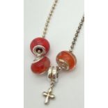 A 22" silver ball chain with lobster clasp, orange tone glass charm beads & a drop cross charm,