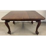 A Victorian mahogany wind out dining table with large ball and claw feet. Complete with 2 additional