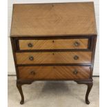 A vintage 3 drawer bureau with brass hooped handles and escutcheons. Drop down writing platform with