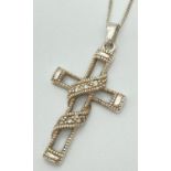 A silver open cross shaped pendant set with clear stones, on an 18" fine curb chain with spring