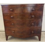 A Victorian mahogany bow fronted 2 over 3 chest of drawers with knob handles. Brass escutcheons to