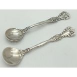 2 vintage decorative silver salt spoons with scroll and floral detail. Both Marked Sterling to back.