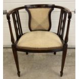 An Edwardian curve backed tub chair with tapered front legs and spade feet. Reupholstered with cream