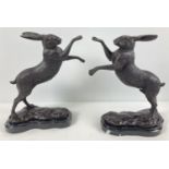 A pair of bronze "boxing hares" figurines mounted on marble bases. Approx. 29cm tall.