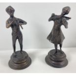 A pair of vintage bronzed effect brass figures playing musical instruments. On circular pedestal