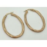 A pair of 9ct gold oval shaped hoop earrings of twisted design. Marked 375 to hinged posts.