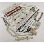 A large quantity of assorted vintage and modern faux pearl necklaces. In varying colours and
