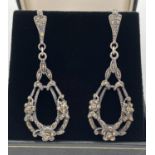 A pair of vintage style large drop silver earrings with marcasite set floral decoration. Total