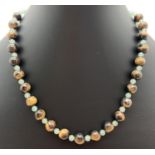 A 15" tigers eye and green aventurine beaded necklace with silver tone S shaped hook clasp. Tigers