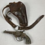 A vintage metal 'Monak' toy cap gun with a leather Ranger holster and belt.