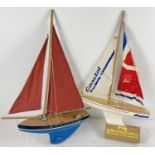 2 vintage pond Yachts. A French Tiroh 501 blue and white yacht with red sails and a white Skipper