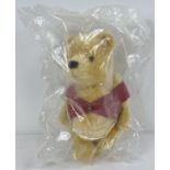 A 10.5" Steiff blond mohair, fully jointed Winnie-the-Pooh teddy bear. With red jacket. In sealed