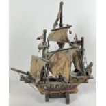 A handmade vintage wooden model of the Hanseatic ship (cog) Hansa Kogge with painted sails.
