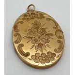 A large vintage oval shaped 9ct gold locket with front floral decoration and engine turned pattern