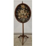 An antique 3 footed short pole screen with oval shaped fine needlepoint floral panel. Turned