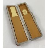 A vintage soft leather and chrome clip case containing two bone page turners. Approx. 14 cm long.