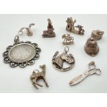 A collection of vintage white metal charms, all with hanging bales. To include fishing basket,