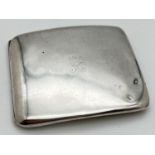 A 1920's silver curve backed slim cigarette case with worn engraved emblem to front. Fully