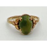 A vintage 9ct gold dress ring set with oval shaped green cabochon. With decorative floral design