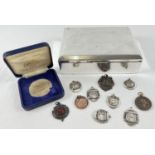 A silver plated cigarette box together with a collection of vintage sports medallions. To include