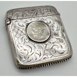An Edwardian silver vesta case with floral decoration throughout and worn sixpence to front. Striker