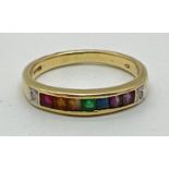 A 14ct gold ring set with 7 square cut channel set rainbow gemstones and flanked by diamonds.