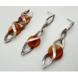 A silver and amber modern design pendant and matching earrings. In a drop style with twist design,