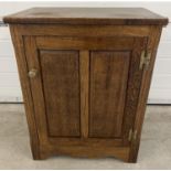 A vintage dark oak cupboard with brass knob handle and interior shelf. Panelled door with push