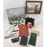 A box of assorted misc items to include binoculars, coins, magnifying glass, stirrups with leather