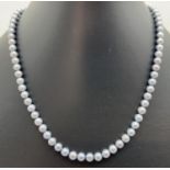 A string of silver blue pearls with 10k gold pierced work clasp. Approx 16 inches long.