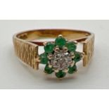 A vintage 9ct gold emerald and diamond dress ring. Bark effect decoration to high shoulders. Small