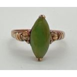 A 9ct gold dress ring set with a marquise cut jade stone. Decorative detail to shoulders. Marked 14K