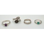 4 silver dress rings. An illusion diamond set in a twist design, a central oval cut amethyst,