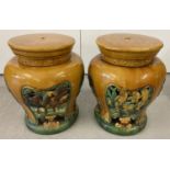 A pair of antique majolica garden stools in brown and green glaze. Circular shaped stools of bulbous