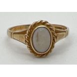 A 9ct yellow gold dress ring set with central oval opal in a twist setting. Fully hallmarked
