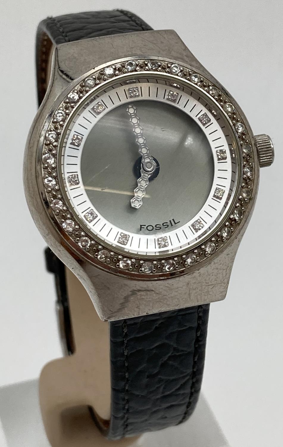 A women's Fossil Big Tic JR-7926 stone set wrist watch with black leather strap. With clear stone