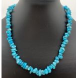 A 17" costume jewellery necklace of rough cut turquoise beads. With a screw barrel clasp.