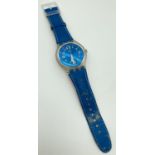 A unisex S216 Swatch watch with metallic blue face and original blue leather strap. Luminescent