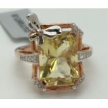 A rose gold vermeil cocktail ring by Gemporia, set with a large emerald cut peridot stone & 19 small