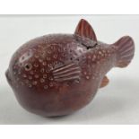 A small Japanese carved fruitwood snuff pot in the form of a pufferfish. Set with small mother of