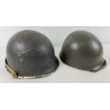 A WWII US M1 steel helmet used by the US Navy, painted grey with factory cork finish. Complete