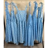 6 matching blue polka dot dresses, 5 of halter neck design.