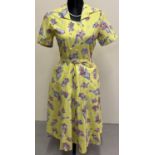 A vintage 1950's yellow cotton belted day dress with floral spay decoration. Pockets to front of