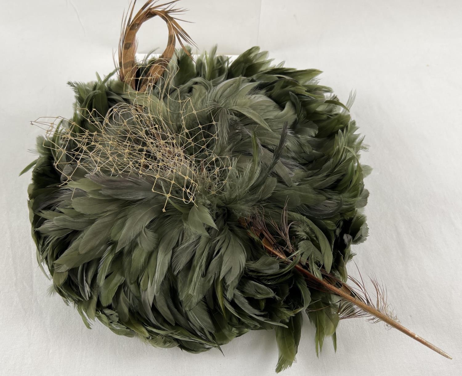 A green feather fascinator style hat with pheasant feather and net detail. Together with a Harvey - Image 2 of 4