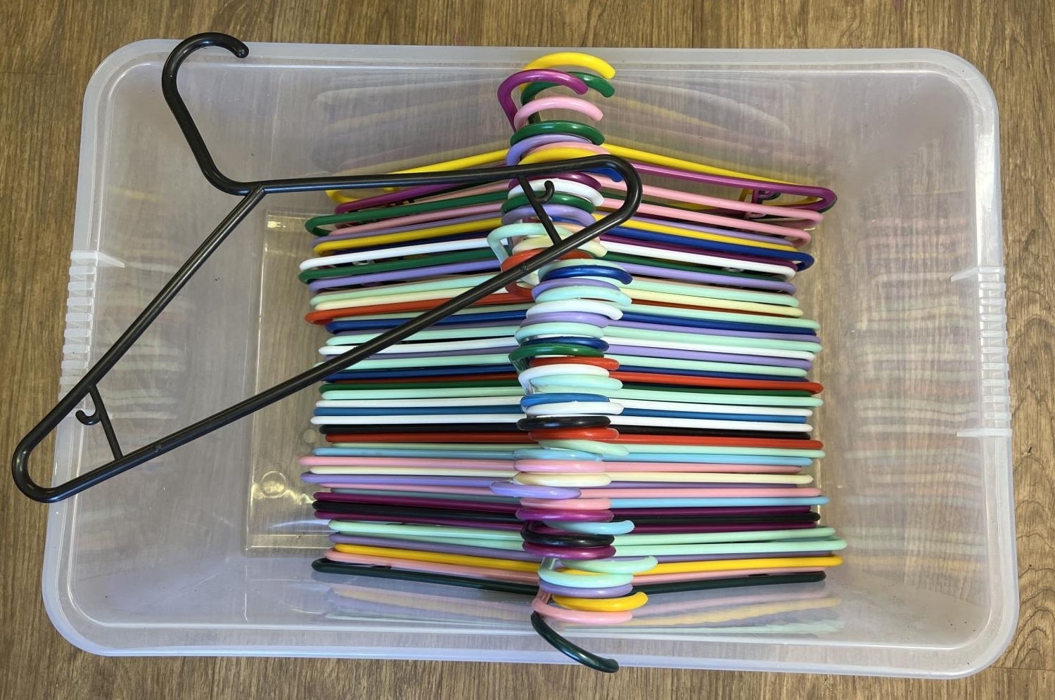 A box of 50 coloured plastic coat hangers of the same design.