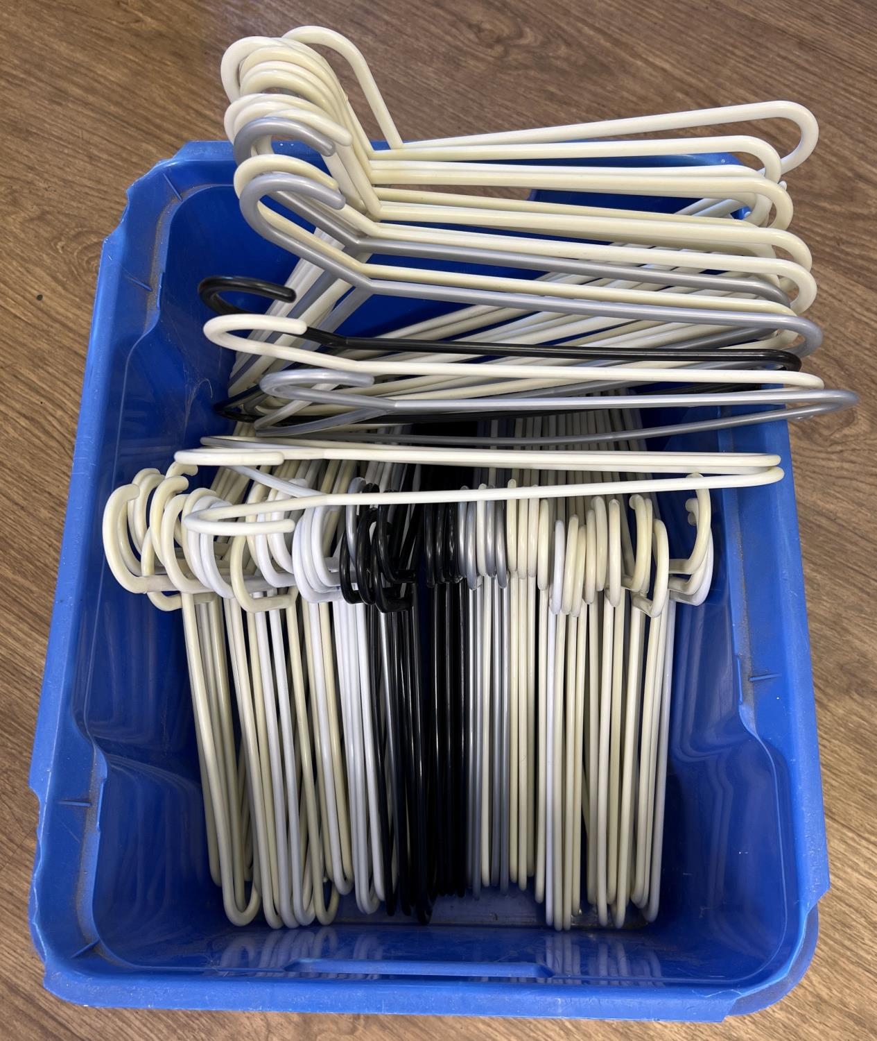 A box of 70 assorted plastic white, black & silver coat hangers, of the same design.