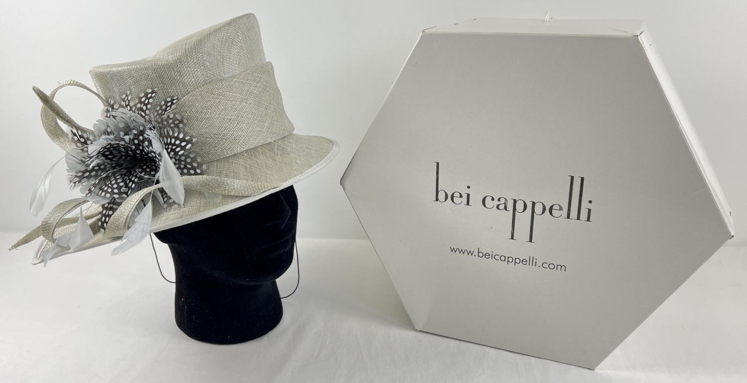 A ladies occasion hat in pearl grey with floral design feather spray to one side. Together with a